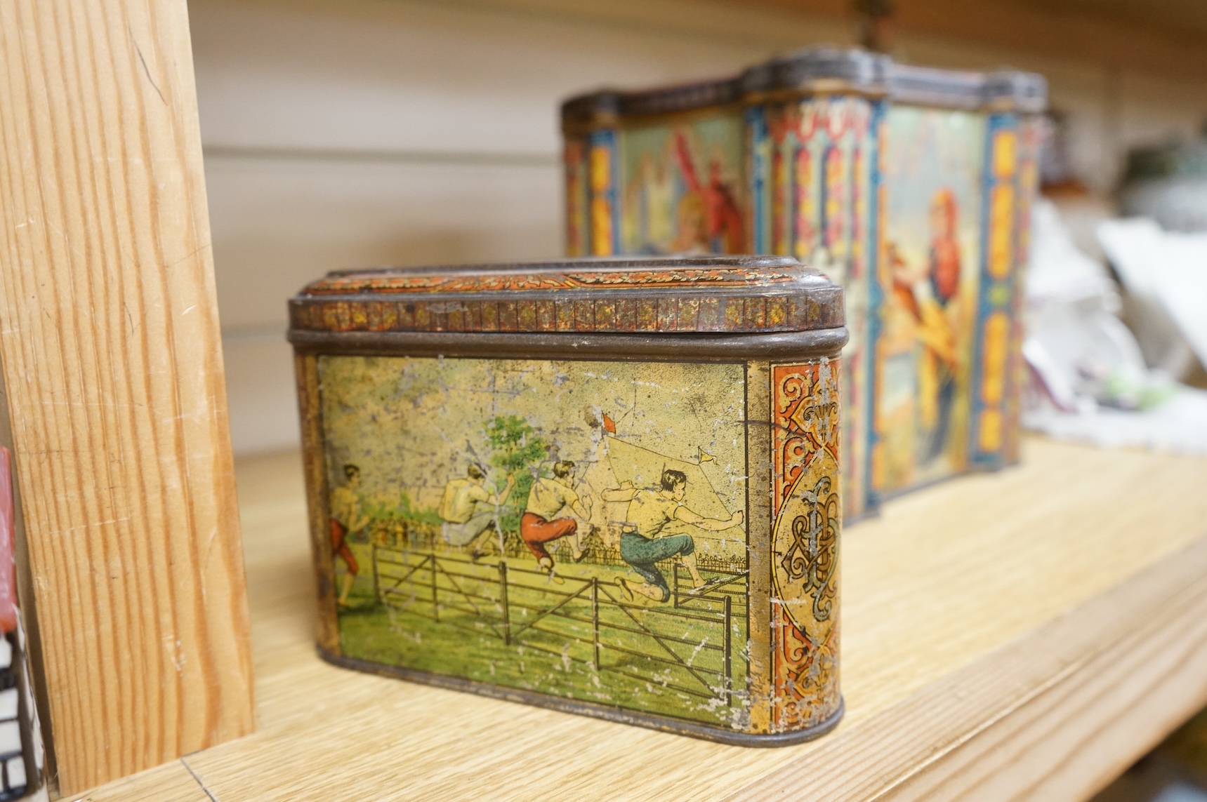 A Windmill biscuit tin by Huntley & Palmer: Reading & London, 'BIVM' Eastern Beauties tea tin and Huntley & Palmers triangular biscuit tin with 'Sports' motifs